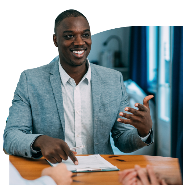 A business man with a clipboard having a conversation in a meeting.